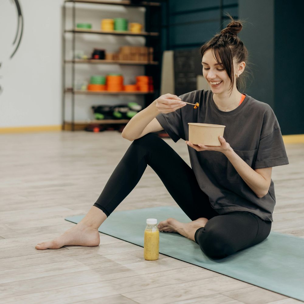 Kvinde spiser et måltid efter træning for at understøtte restitution og muskelopbygning